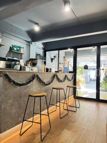 a bar in a restaurant with two stools and a counter at The Moment Hostel in Bangkok