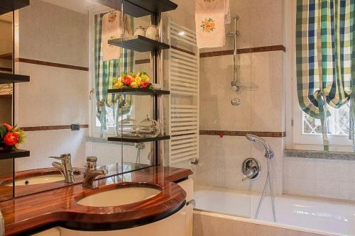 a bathroom with a sink and a bath tub at Villa Ametista in Meina
