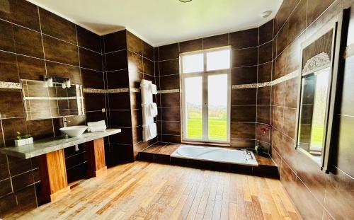 a bathroom with a tub and a sink and a window at Château des Fougères Trouville sur Mer in Trouville-sur-Mer