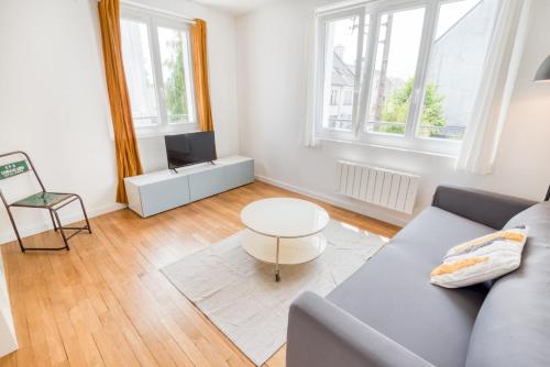 un salon avec un canapé et une table dans l'établissement Paisible appartement Central & lumineux par Groom, à Lorient