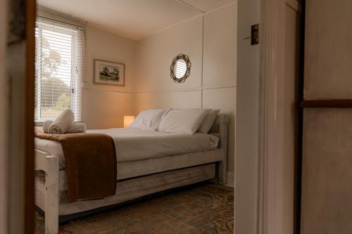 a bedroom with a bed and a window at Paddys Shack - the bush spa! in St Helens