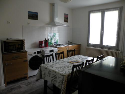 une cuisine avec une table et une cuisine avec une cuisinière dans l'établissement Coquelicot, Entre Volcans d Auvergne et Sancy, Orcival., à Orcival