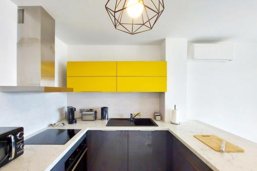 - une cuisine avec des placards jaunes et un évier dans l'établissement Kiara - Beach by foot terrace Isolella - by TGB, à Pietrosella