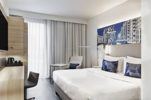 a hotel room with a large bed and a chair at Courtyard by Marriott Hamburg City in Hamburg