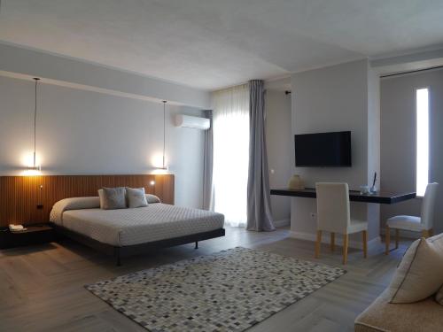 a bedroom with a bed and a desk and a television at Hotel Tonnara Trabia in Trabia