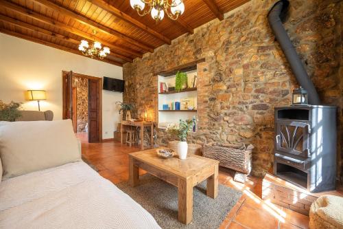 a living room with a stone wall with a couch and a wood stove at Casa Rural Casa Selmo in Carreno