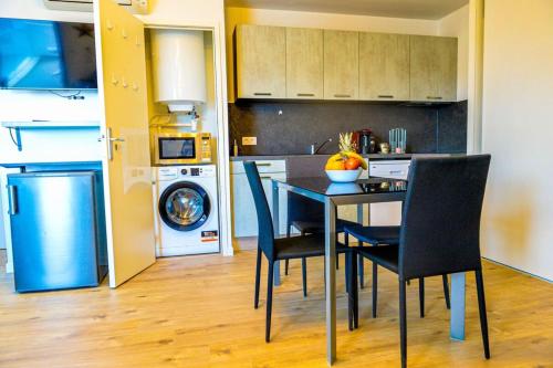 - une cuisine avec une table à manger et des chaises dans l'établissement Paolina - Terrasse Parking Clim wifi - by TGB, à Ajaccio