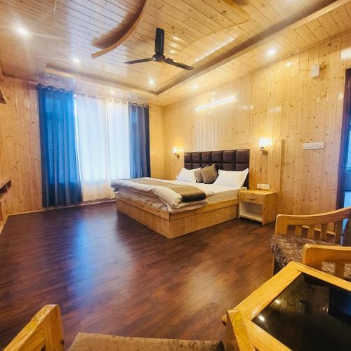 a bedroom with a bed in a room with wooden walls at Ekaant Stays - Manali in Manāli
