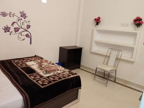 a room with a bed and a chair in it at Rudra Guest House in Rāmnagar