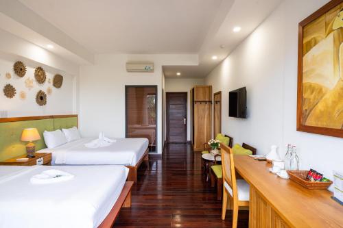 a hotel room with two beds and a dining room at Palm Riverside Boutique in Hoi An