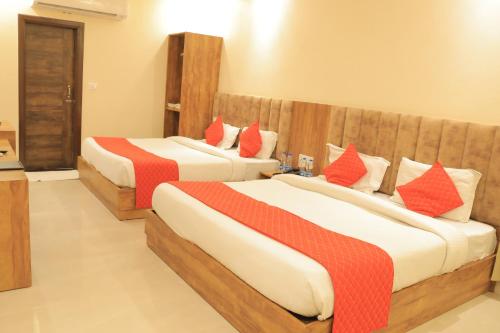 two beds in a hotel room with red pillows at Hampton Hotel - 200 mt from Golden Temple in Amritsar