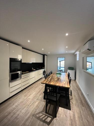 une grande cuisine avec une table et des chaises en bois dans l'établissement L'Olivier - Joli duplex au cœur du centre ville à 2 pas de la Rotonde Mirabeau et des allées Provençales, à Aix-en-Provence