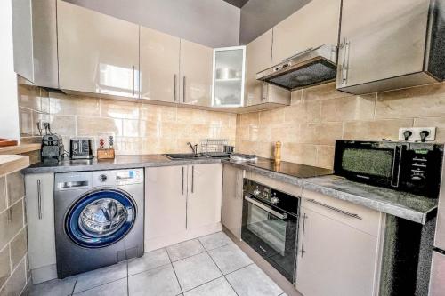 une cuisine avec un lave-linge et un lave-linge dans l'établissement Flavia - Central Balcony Glimpse of the sea, à Ajaccio
