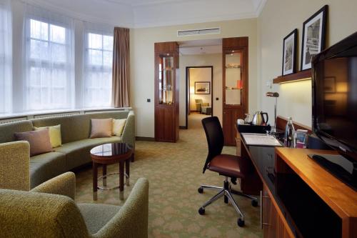 a hotel room with a couch and a television at Courtyard by Marriott Bremen in Bremen