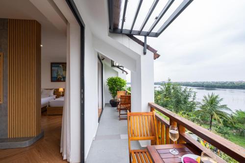 a room with a balcony with a view of a river at Palm Riverside Boutique in Hoi An