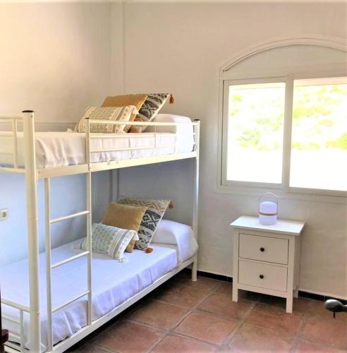 a bedroom with two bunk beds and a window at Villa Perla in Zahara de los Atunes