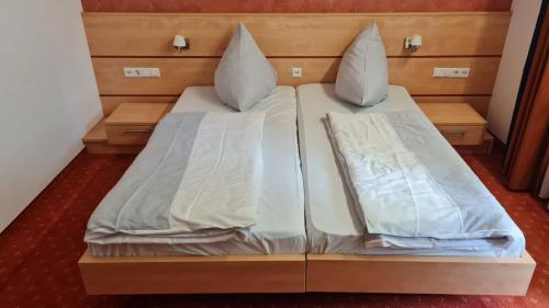 a bed with two pillows on it in a room at Terra Ventura Hotel in Gondorf