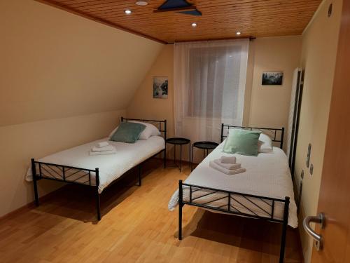 Dos camas en una habitación con techos de madera. en Mb Homes Pfullingen 2, en Pfullingen
