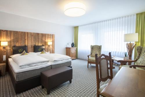 a hotel room with a bed and a table and chairs at Romantikhotel Platte in Attendorn