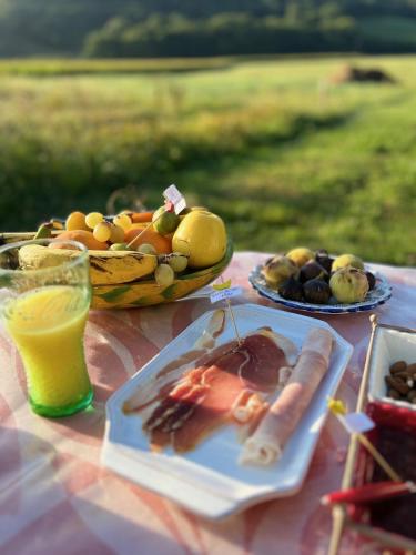 Gîte au calme avec balnéo privée في Balansun: طاولة وصحون طعام وسلة فاكهة