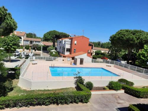 - une vue sur la piscine en face d'une maison dans l'établissement Appartement 2 pièces cabine 5 couchages ST CYPRIEN SC895-30A, à Saint Cyprien Plage