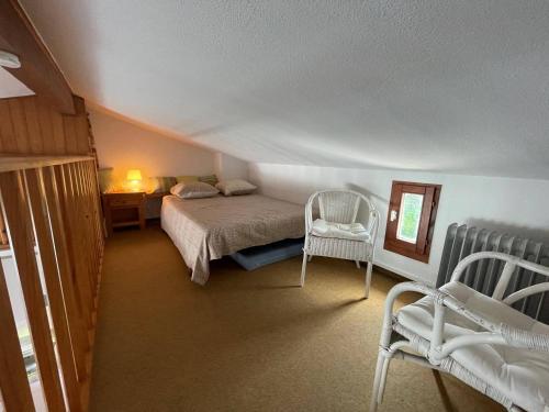 - une chambre mansardée avec un lit et des chaises dans l'établissement Appartement 2 pièces cabine 5 couchages ST CYPRIEN SC895-30A, à Saint Cyprien Plage