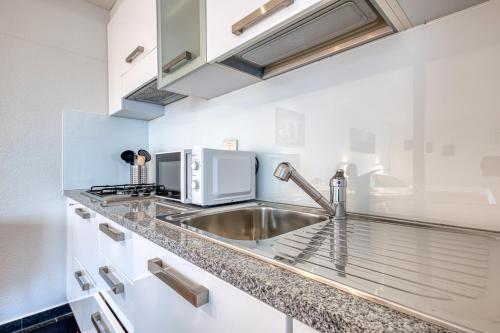a kitchen with a sink and a microwave at Residence Margherita in Ugento
