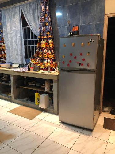 a refrigerator in a kitchen with a christmas tree at Logerthine Cambridge Suriname in Paramaribo