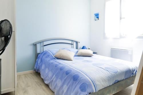- un lit avec une couette bleue et blanche dans une chambre dans l'établissement Maison au calme, proche océan, Les Sables 6 personnes, à Les Sables-dʼOlonne