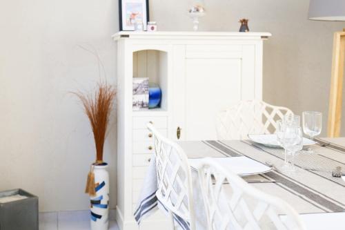 une salle à manger avec une table et des chaises blanches dans l'établissement Maison au calme, proche océan, Les Sables 6 personnes, à Les Sables-dʼOlonne