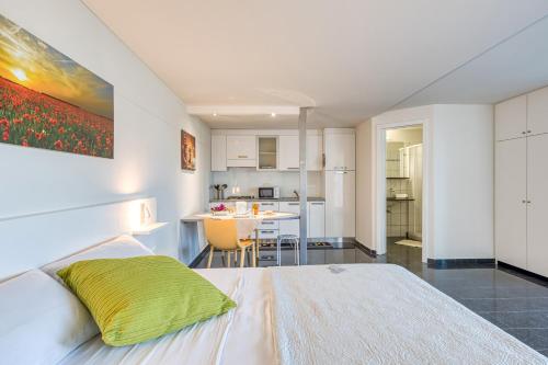 a bedroom with a white bed and a kitchen at Residence Margherita in Ugento