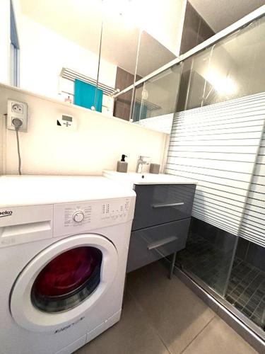 une machine à laver dans une salle de bain avec un lavabo dans l'établissement Estivales 2, à Saint-Raphaël