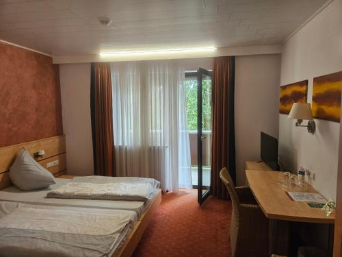 a hotel room with a bed and a desk with a computer at Terra Ventura Hotel in Gondorf