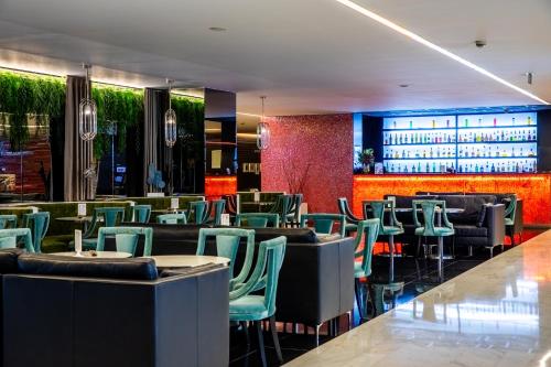 a restaurant with green chairs and a bar at VIP Grand Lisboa Hotel & Spa in Lisbon