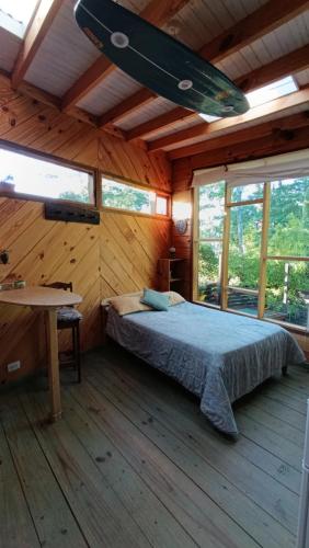 a bedroom with a bed in a wooden house at Del Bosque Surf Ranch in Villa Gesell