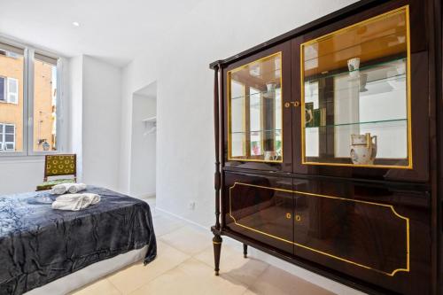 a bedroom with a large wooden cabinet and a bed at Madonuccia - Hypercentral Chic & Cosy - by TGB in Ajaccio