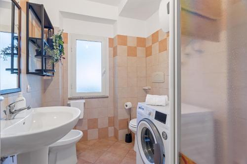 a bathroom with a sink and a washing machine at Casa Mulas in Tertenìa
