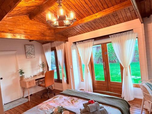 a bedroom with a bed and a desk and windows at Blissful Wooden Haven - complete place is yours 5 min drive or train from parramatta in Wentworthville