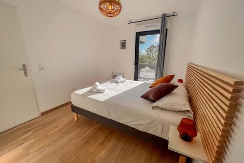 une chambre avec un grand lit et une grande fenêtre dans l'établissement Ornella - Terrace Wifi Cozy - by TGB, à Ajaccio