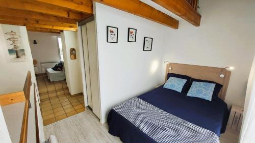 une chambre avec un lit avec des oreillers bleus dessus dans l'établissement Escale à la mer, plage de Royan à pied et balcon, à Saint-Georges-de-Didonne