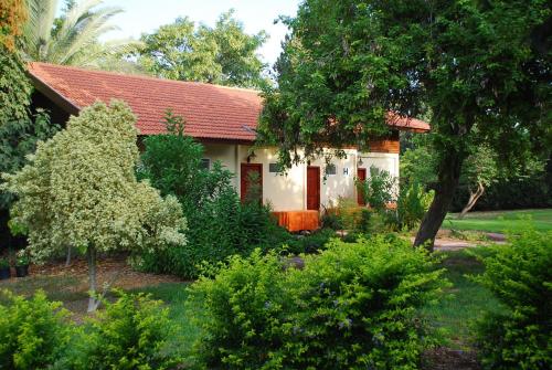 a small white house with a red roof at Holiday Village Kibbutz Mizra in Mizra‘