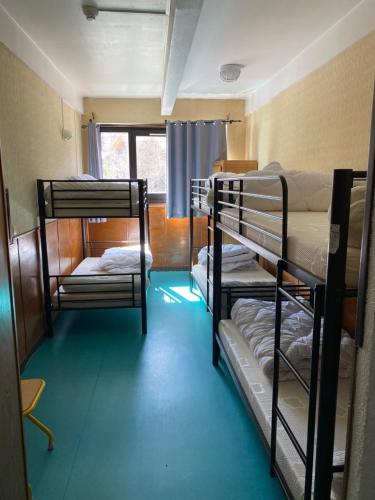 une chambre avec trois lits superposés et une fenêtre dans l'établissement Auberge de Jeunesse - Les Carlines I, à Vars