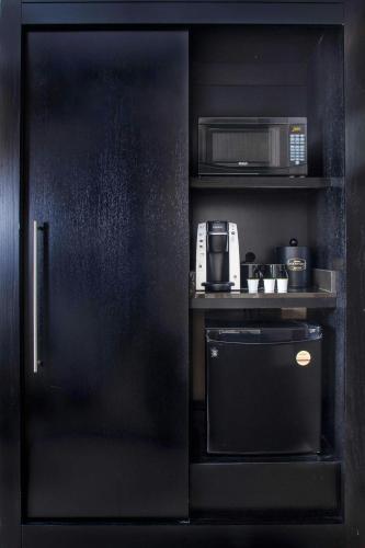 a black kitchen with a microwave and a coffee maker at Courtyard by Marriott New York JFK Airport in Queens