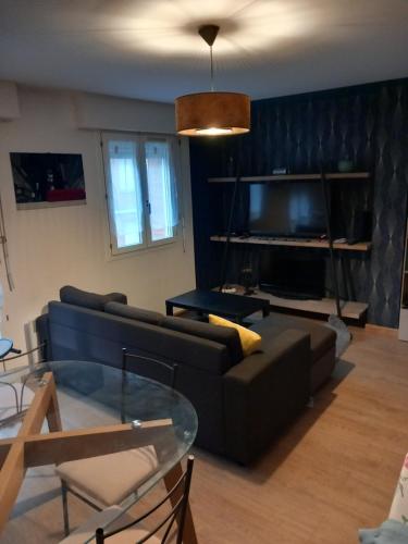 un salon avec un canapé et une table en verre dans l'établissement Apparemment Amiens F2, à Amiens