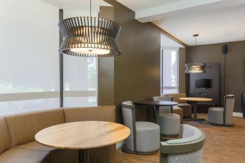 a waiting room with tables and a couch at Courtyard by Marriott Monroe Airport in Monroe
