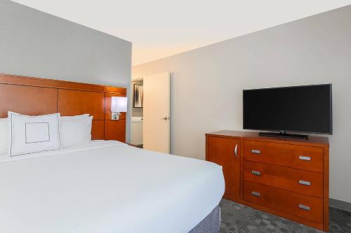 a hotel room with a bed and a flat screen tv at Courtyard by Marriott Monroe Airport in Monroe