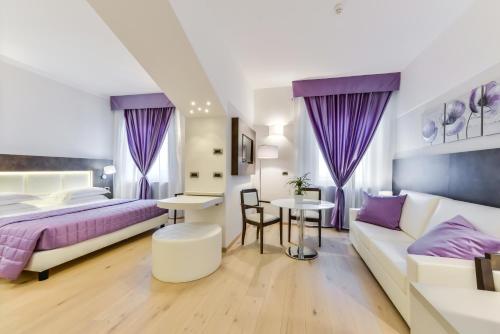 a bedroom with a bed and a couch and a table at Hotel Bologna Airport in Bologna