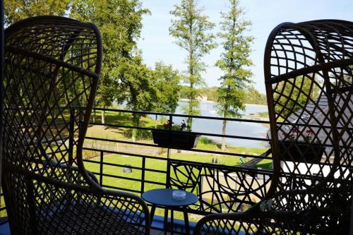 two chairs sitting on a balcony with a view of a river at Loftconcept57 in Kerprich-aux-Bois