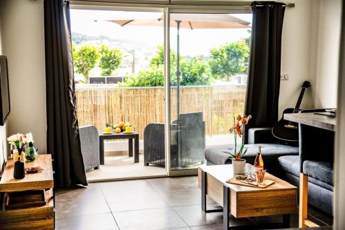 un salon avec vue sur un patio dans l'établissement Francesca - Beach by foot Terrace - by TGB, à Porticcio