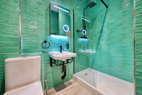 a green tiled bathroom with a sink and a shower at Large Central Station 2 Bed Apartment A2 in Glasgow